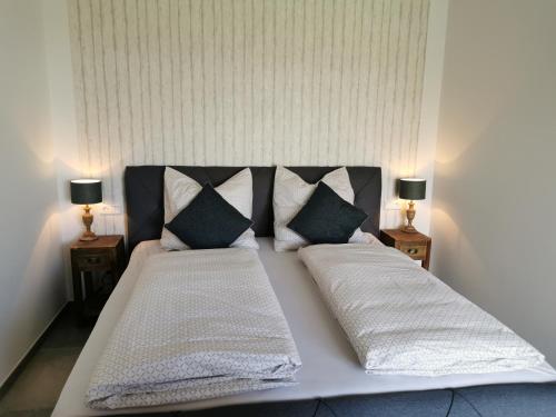 韦策Heeser Hof - Urlaub im Grünen的一张大床,配有两个枕头和两盏灯