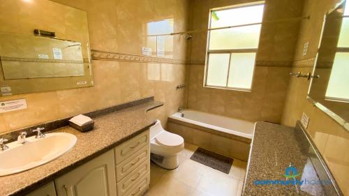 基多Community Hostel Quito的一间带水槽、卫生间和镜子的浴室