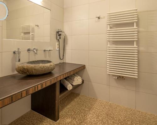 吕本瑙Hotel und Restaurant Zum Deutschen Hause的一间带石质水槽和电话的浴室