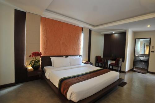 坤敬魅力精品度假酒店的酒店客房设有一张大床和一张桌子。