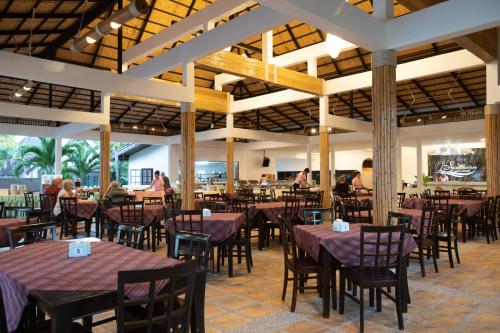 高兰Southern Lanta Resort - SHA Extra Plus的餐厅设有桌椅,背景人员