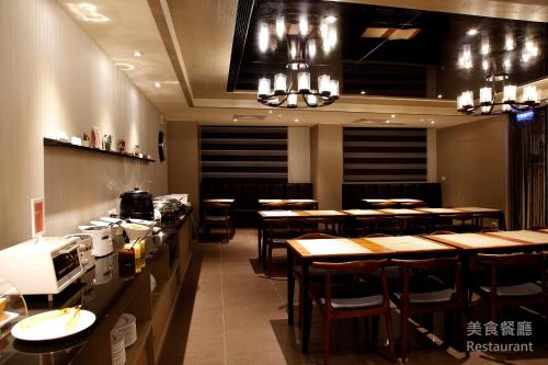 台北百丽商务旅馆的一间设有木桌和椅子的餐厅