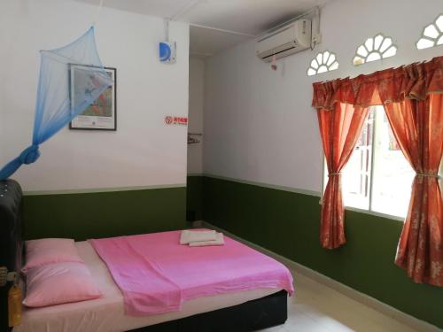 瓜拉大汉德利马旅馆的卧室配有粉红色的床和窗户。
