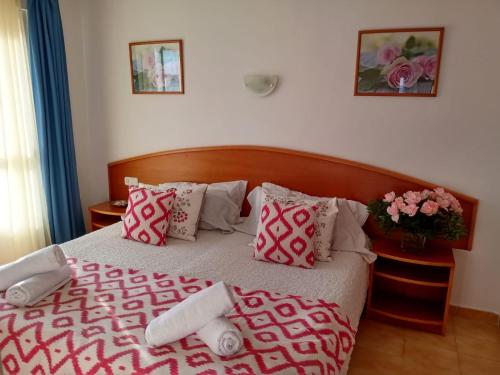 卡拉米洛Apartamentos Villa Margarita的一间卧室配有带粉色和白色枕头的床