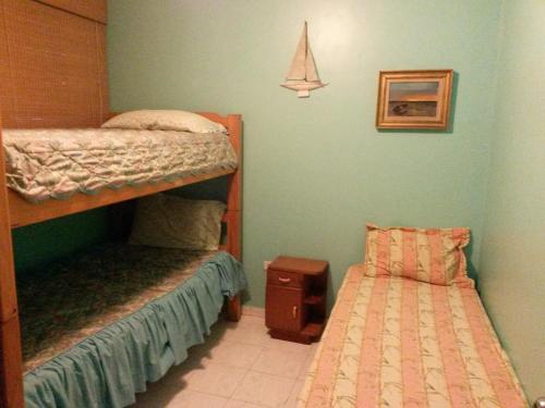 TucacasCosta Grande Tucacas Morrocoy的一间卧室配有两张双层床和一张小床。