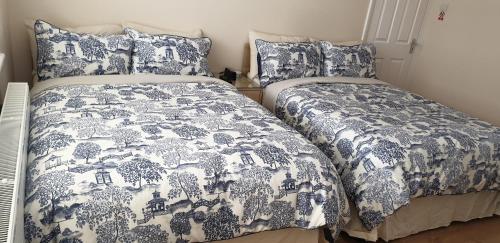 伦敦London Luxury 3 Bedroom Flat 1min walk from Underground, with FREE PARKING Sleeps x10的卧室内的两张床,配有蓝色和白色的床上用品
