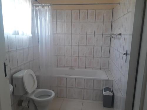 维多利亚瀑布Chitova’s Guesthouse的浴室配有卫生间、浴缸和水槽。