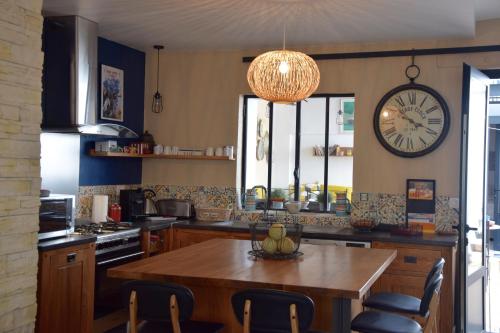 艾格-莫尔特Le Petit Patio的厨房配有桌子和墙上的时钟