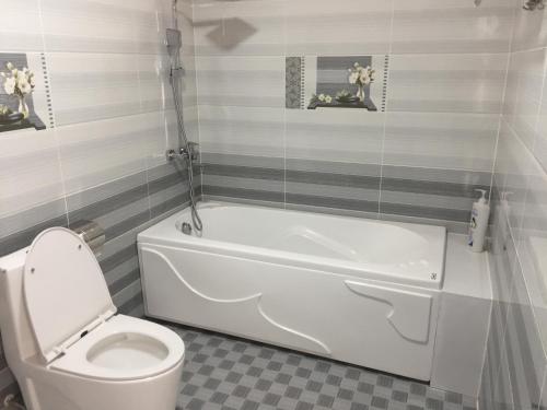 Xóm Mỹ CaLong Hồ Homestay的浴室配有白色浴缸和卫生间。