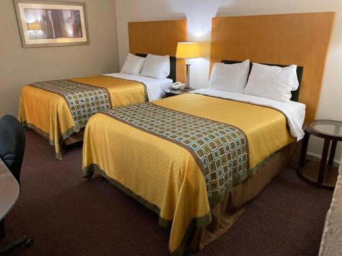 章克申城Great Western Inn的酒店客房带两张带黄床单的床