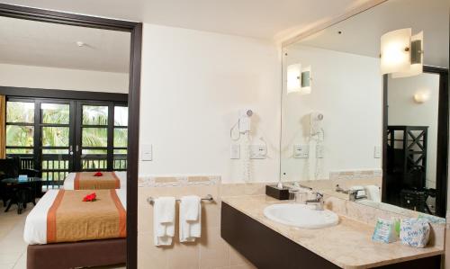 科罗雷乌纳维蒂度假酒店的一间带水槽、床和镜子的浴室