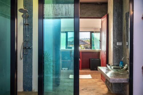 万荣萨图楠姆比奇度假村的一间带玻璃淋浴和水槽的浴室