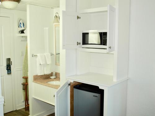 杜威海滩Atlantic View Hotel的白色的厨房配有微波炉和水槽