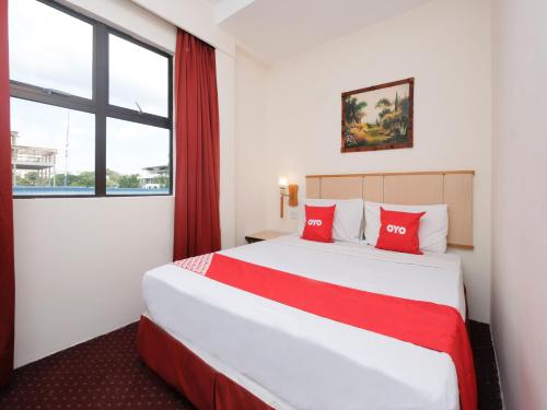 八打灵再也OYO 89968 Sri Sutra Hotel的酒店客房配有一张带红色枕头的大床