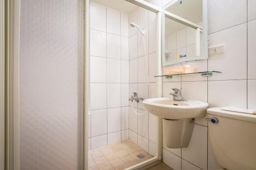 埔里亚缔旅店的白色的浴室设有水槽和淋浴。