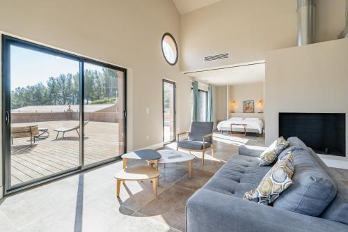 拉卡迪埃达聚Loft d'architecte au coeur d'un domaine viticole的客厅设有蓝色的沙发和大窗户