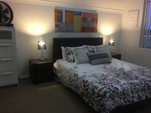 曼哲拉Villa Serenity On The Terrace的一间卧室配有一张带枕头的床和两盏灯。