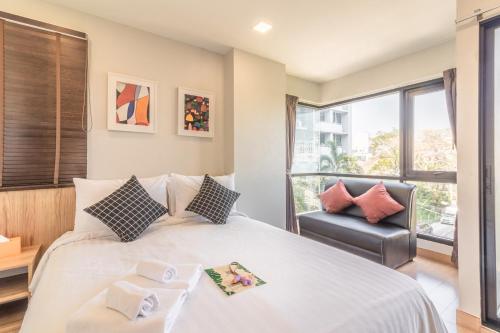 曼谷Casa Luxe Hotel and Resident的一间卧室配有一张大床和一把椅子