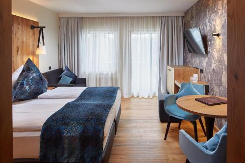 埃尔毛伊尔玛因提洛尔运动酒店的酒店客房配有一张床铺和一张桌子。