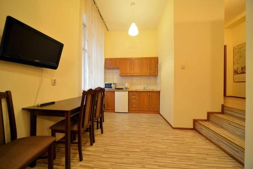 罗兹Apartaments Piotrkowska 101的厨房配有桌椅和电视。