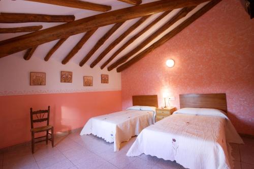 努瓦洛斯拉斯茹姆巴斯酒店的配有橙色墙壁和木梁的客房内的两张床