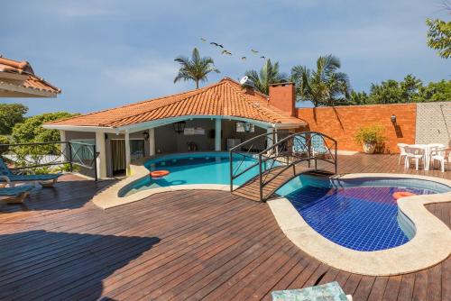 博尼图VOA Hotel Paraíso das Águas Bonito的木甲板上设有游泳池的房子