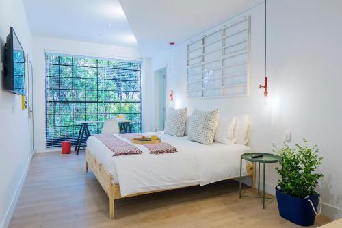 波哥大Casa Legado的一间卧室设有一张床和一个大窗户