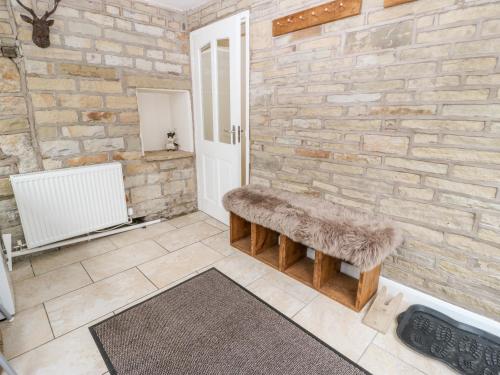 奥尔德姆Wren Cottage的一间带石墙和长凳的浴室