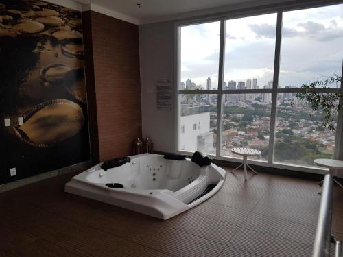 戈亚尼亚Flat mobiliado em região nobre de Goiânia的带浴缸的浴室和大窗户
