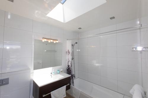 特卡波湖三河旅馆的白色的浴室设有水槽和淋浴。