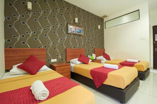 甘榜龙溪布城&赛城科普酒店的一间卧室设有两张红色和黄色的床