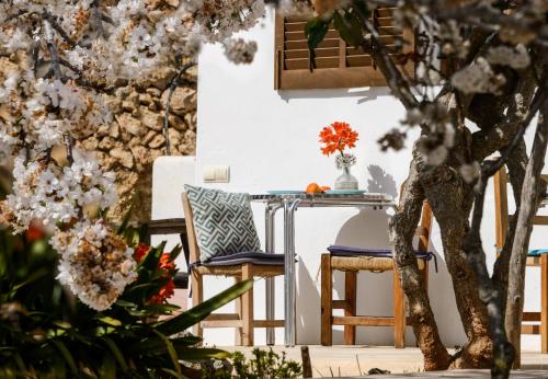 圣卡洛斯Agroturismo rural Can Prats的鲜花庭院里的桌椅