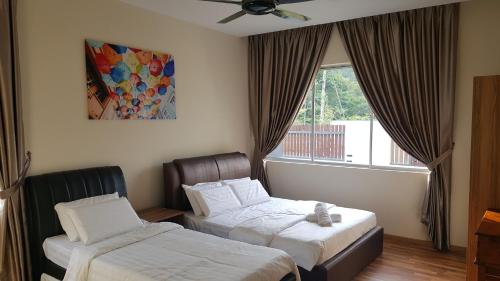 帕帕尔Seri Jati Homestay的酒店客房设有两张床和窗户。