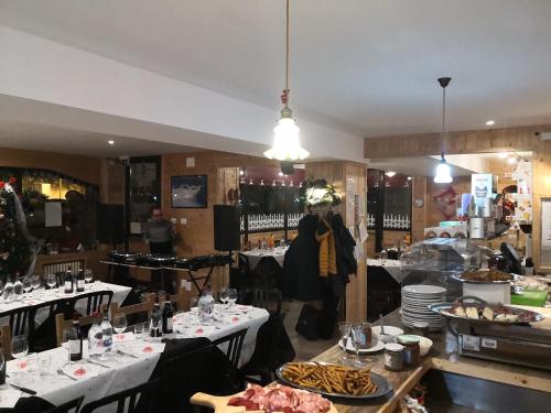 利莫内皮埃蒙特B&B La Locanda del Colle e ristorante的餐厅设有白色桌子,提供食物