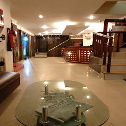 古瓦哈提Hotel Geetanjali的建筑中间带玻璃桌的房间