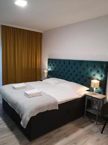 奥普尔Apartamenty Lawendowy Zakątek 2的一间卧室配有一张大床和蓝色床头板