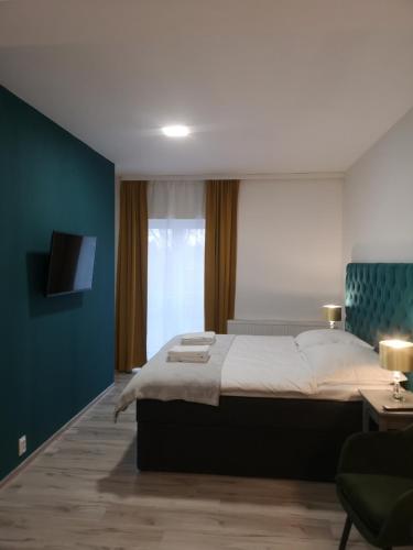 奥普尔Apartamenty Lawendowy Zakątek 2的一间卧室设有一张大床和蓝色的墙壁