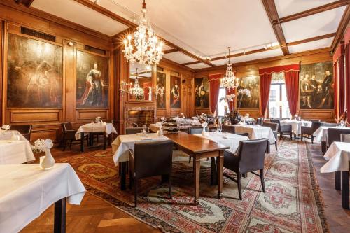 吕伐登弗莱彻酒店的一间带桌椅和绘画的用餐室