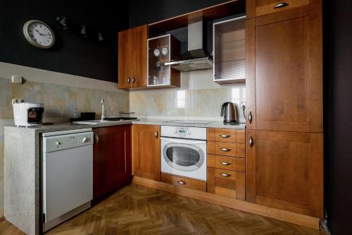卢布林Centro的厨房配有木制橱柜和白色洗碗机。