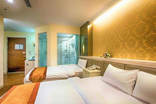 台东中华典藏商旅的酒店客房设有两张床和淋浴。