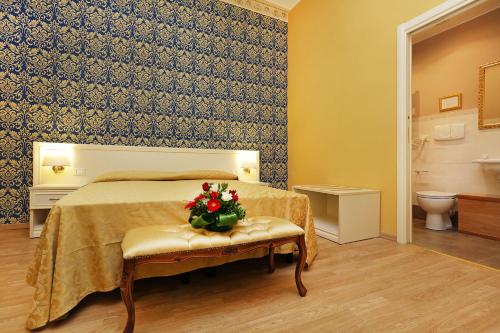 罗马DG尊贵房酒店的一间卧室,配有一张床上的插花床