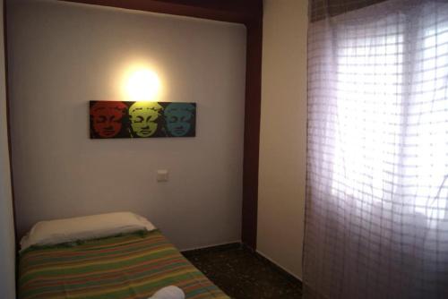 伊维萨镇Ceibo Ibiza - Guest House的一间设有一张床的房间,墙上有灯