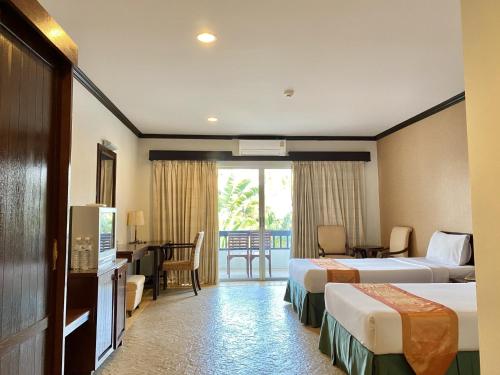 盼武里金松滩海滩度假酒店的酒店客房配有两张床和一张书桌