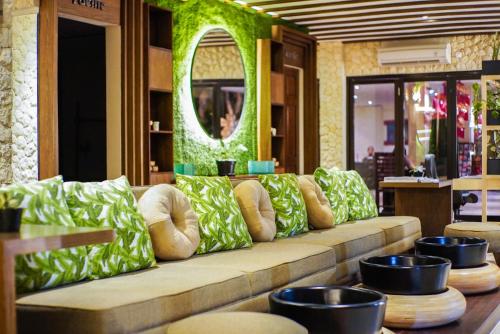 勒吉安巴厘岛水明漾富丽华海滩酒店的一张长沙发,位于带镜子的房间里