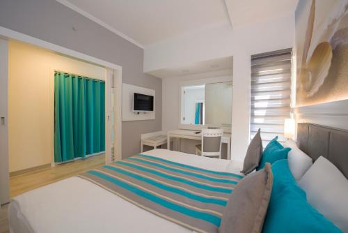 达拉曼TUI BLUE Tropical的一间卧室配有一张大白色床和蓝色毯子