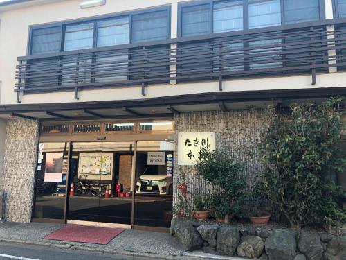 京都泷川旅馆 的前面有窗户和植物的建筑