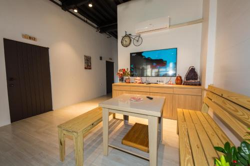 小琉球岛小琉球八八民宿的客房设有桌子、长凳和电视。