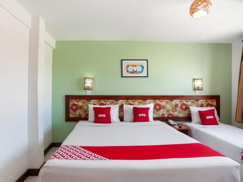 阿拉卡茹OYO Alto Da Praia Hotel, Aracaju的一间卧室配有两张带红色枕头的床