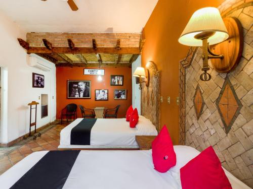 蒙克洛瓦Hotel Olimpia的一间酒店客房,配有两张床和红色枕头