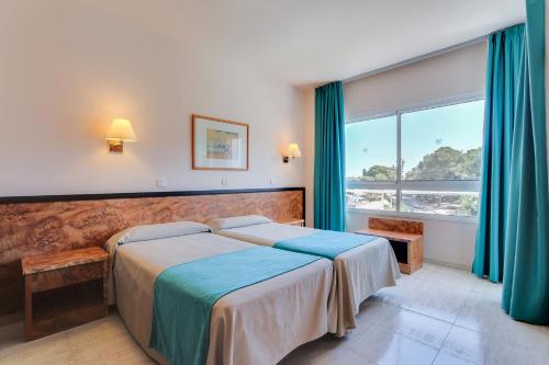 罗列特海岸Hotel Gran Garbi Mar & AquaSplash的一间卧室设有一张床和一个大窗户